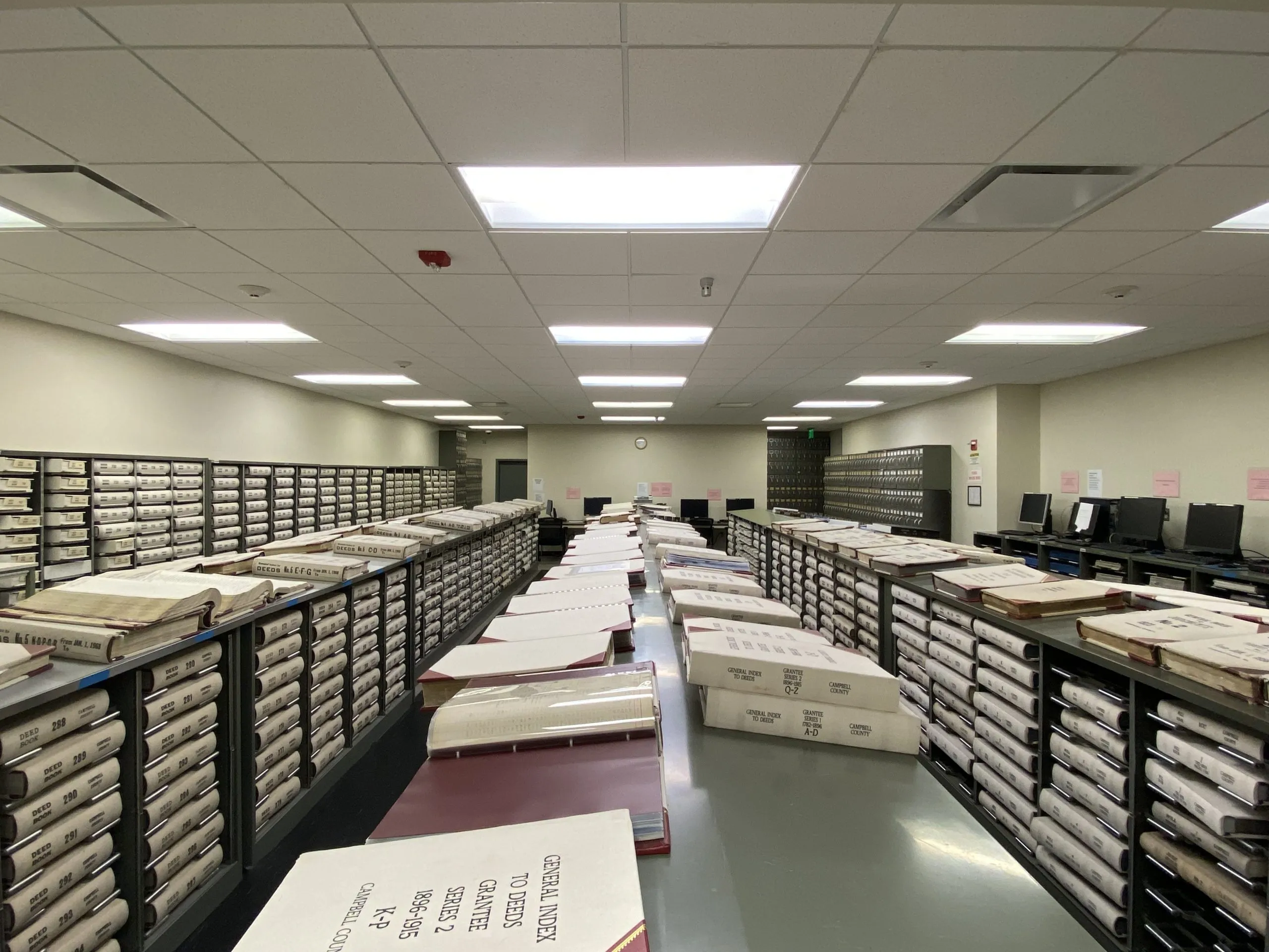 A courthouse records window with a clerk counter and shelves of file boxes in the background
