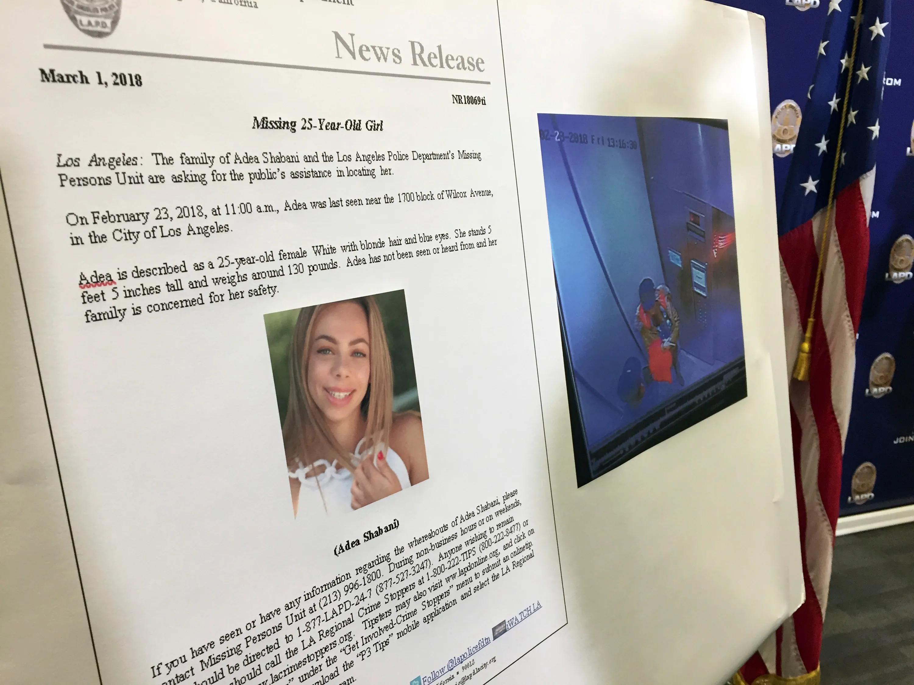 A missing-person poster for Adea Shabani held at a community search gathering