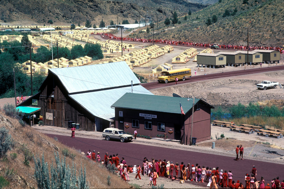 A wide view of the Rajneeshpuram compound in rural Oregon with clustered buildings and surrounding open land
