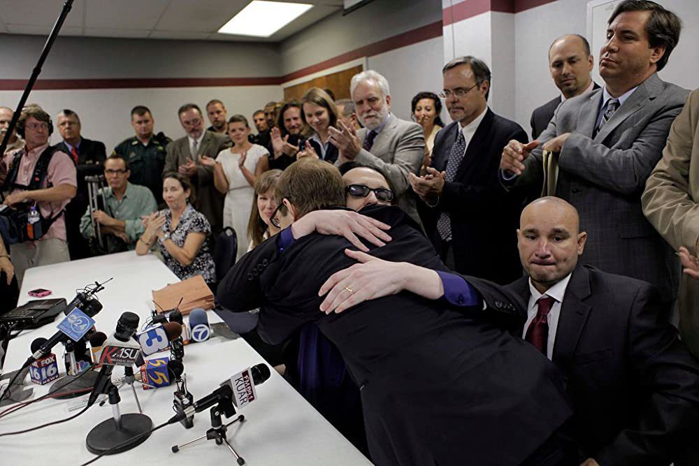 Damien Echols walking outside an Arkansas courthouse after his 2011 release, with supporters and reporters nearby