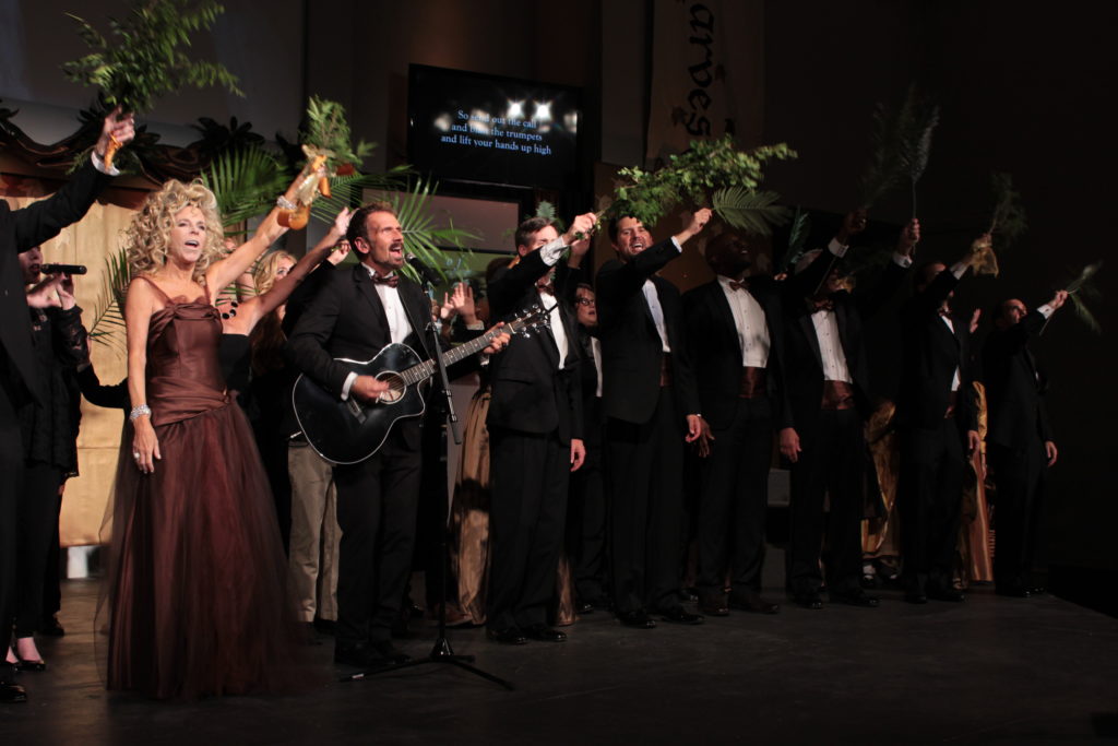 Gwen Shamblin stands on a church stage speaking into a microphone while congregants watch
