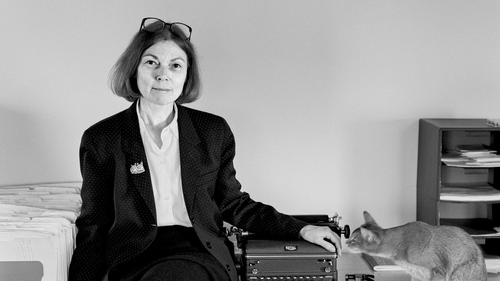 Janet Malcolm seated indoors with a thoughtful expression
