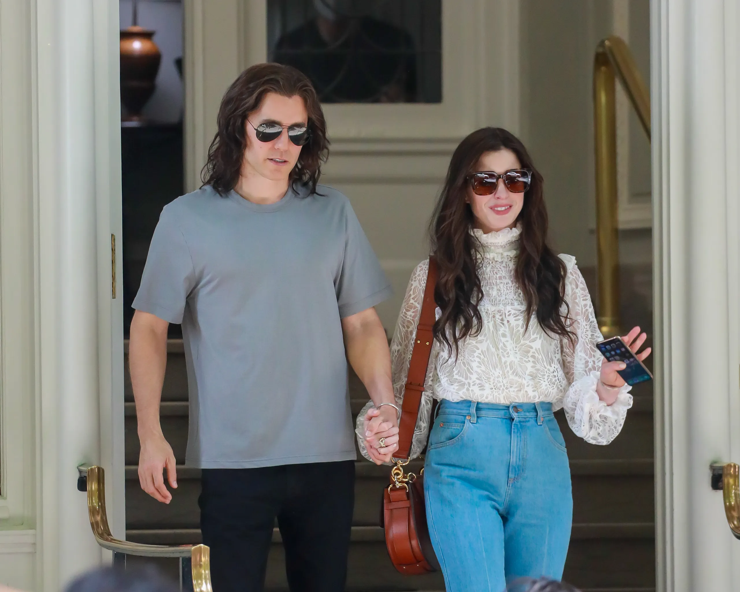 Jared Leto and Anne Hathaway standing close together in a modern office mid-conversation in a television drama still