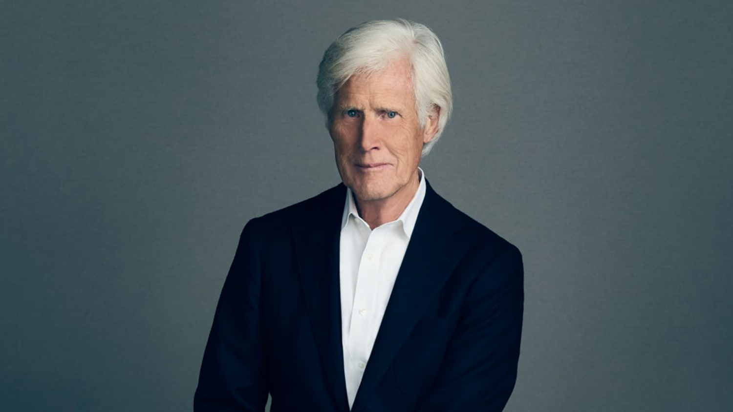 Keith Morrison in a studio setting, dressed in a suit, with a neutral expression as broadcast lighting frames his face