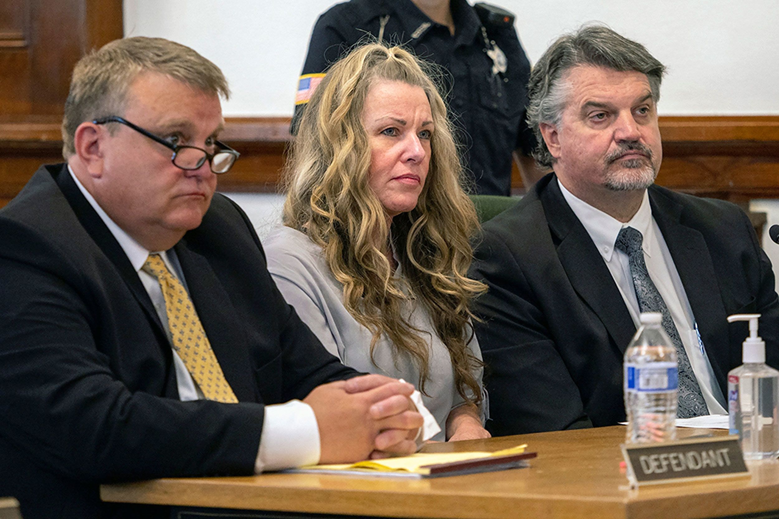Lori Vallow Daybell walking outside a courthouse with attorneys as television cameras and reporters gather nearby