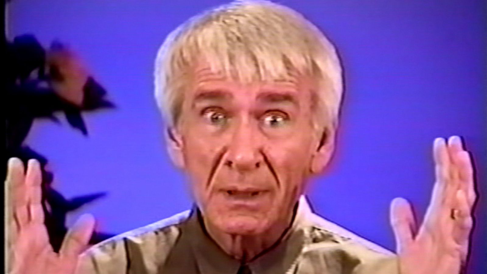 Marshall Applewhite speaking directly to camera in an indoor setting