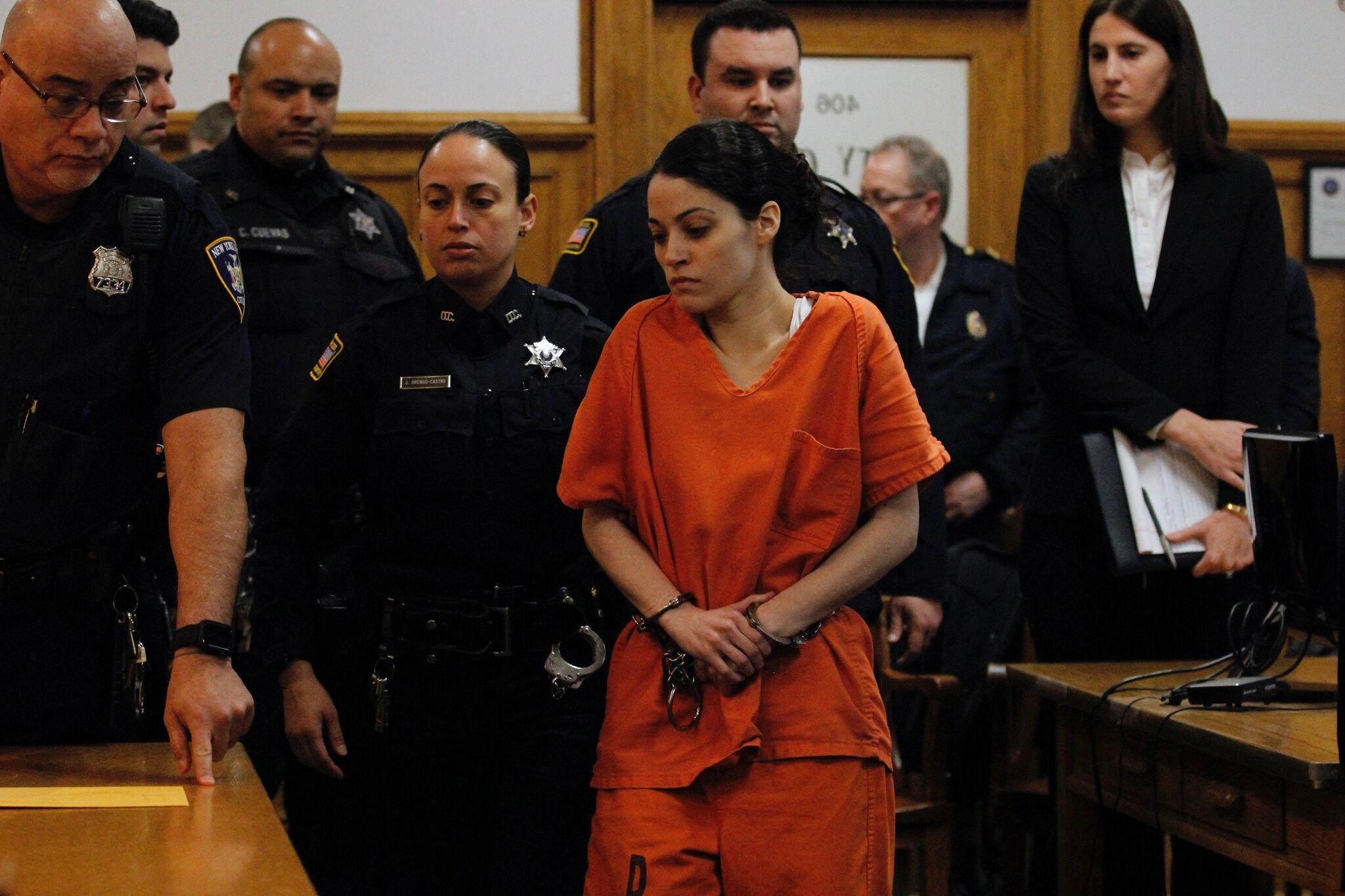 Nikki Addimando walks outside a courthouse alongside her attorneys as reporters and cameras gather nearby
