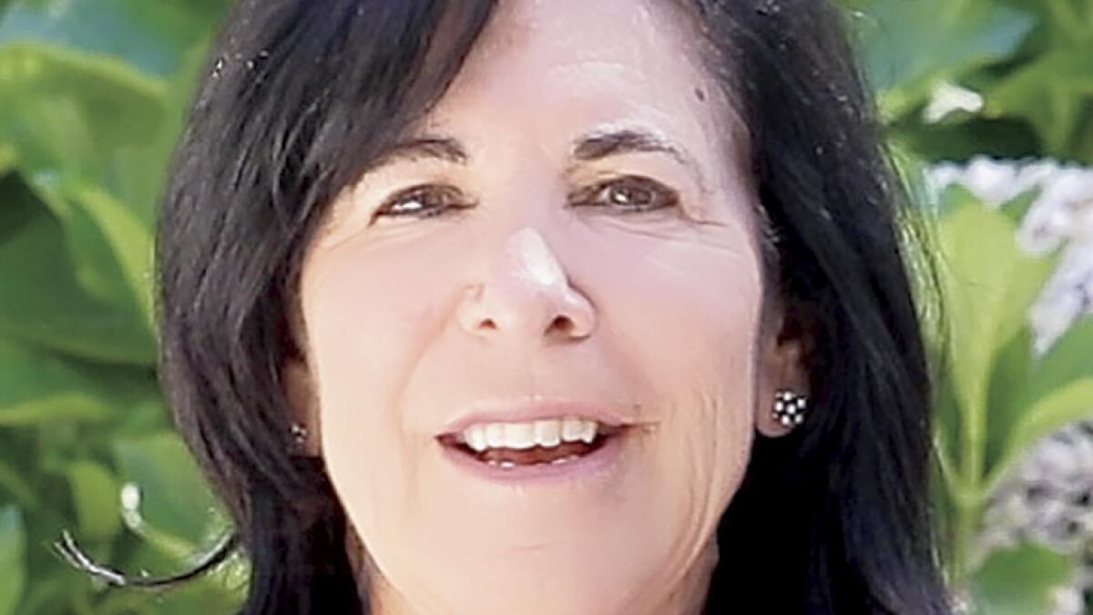 Susan Berman smiling at an event with other attendees behind her