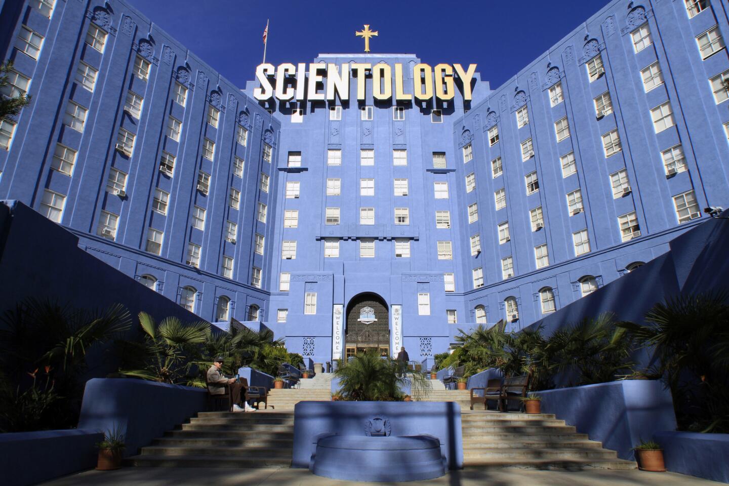 The Church of Scientology headquarters building in Los Angeles seen from street level at dusk with lights visible inside